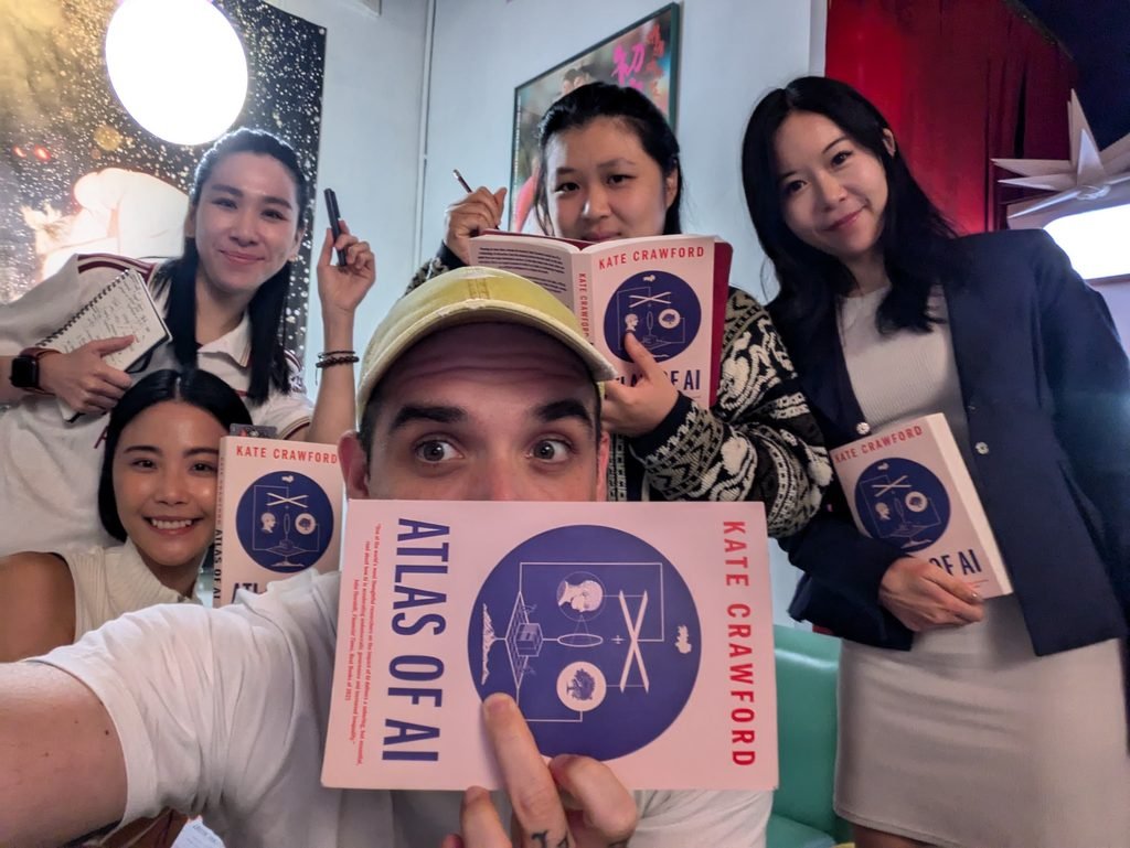 Members of the Critical AI Reading group holding copies of Karen Hao's Empire of AI 